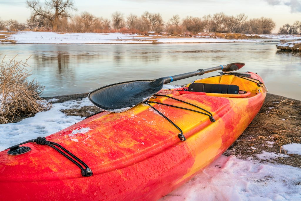 winter kayaking in Colorado - red whitewater kayak with a paddle